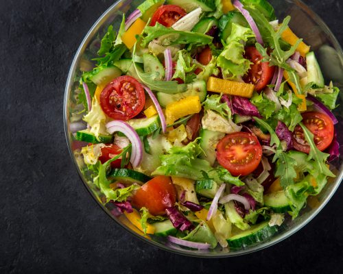 tomatoes, bell pepper, cucumber, lettuce and red onion salad, top view