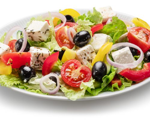 Greek salad on white plate isolated on white background. File contains clipping path.