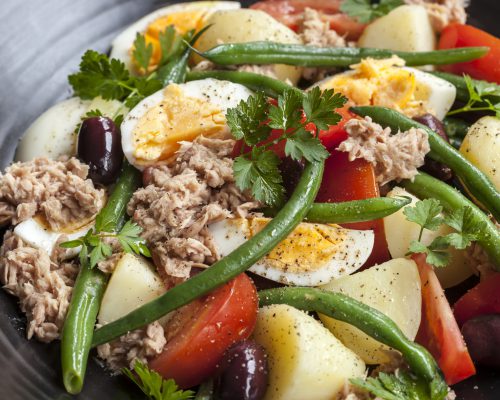 Salad nicoise.  Tuna with baby potatoes, eggs, beans, tomatoes, olives and parsley.